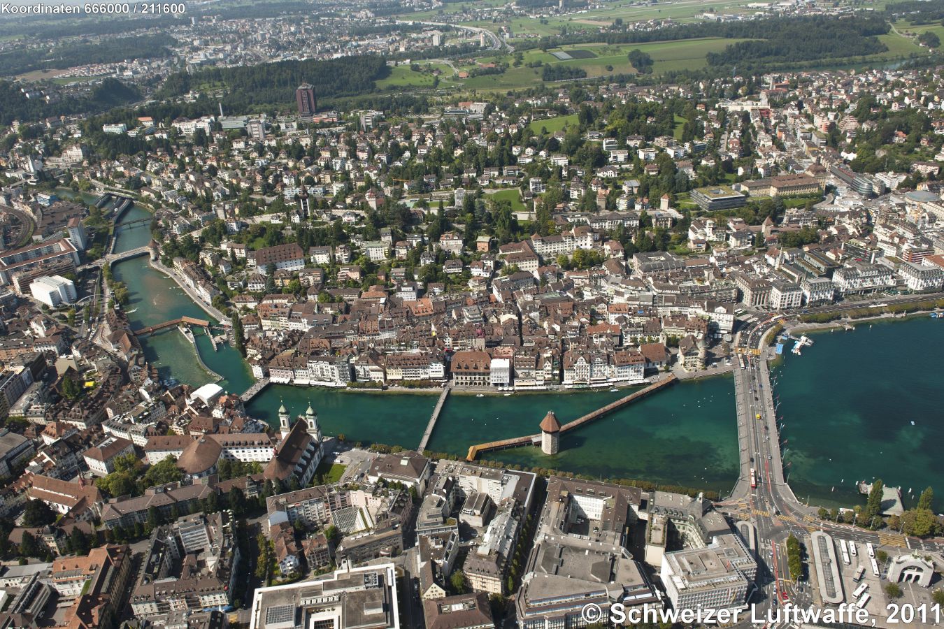 Luzern Altstadt im Zentrum des Bildes, gegenüber am linken Reussufer: Jesuitenkirche. Linker Bildrand Mitte: 'BaBel'-Quartier. Hohes rotes Gebäude im Hintergrund: Spital. Rechter Bildrand Mitte: Bourbaki-Panorama (grünes, rundes Dach); obere rechte Bildecke: Rotsee. Siedlung oberer Bildrand links: Emmenbrücke. Linke obere Bildecke: Sempachersee.
